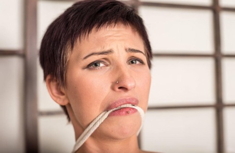Short haired female sports a message on soles of feet while bound and gagged