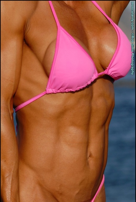 Asian bodybuilder Jennifer Dejoya poses in a pink bikini on a beach 51769443