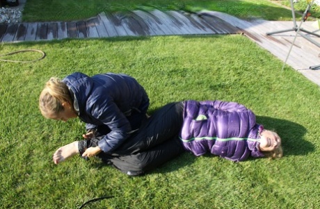 Blonde lesbian is tied up and soaked on a lawn in winter clothing 98617691
