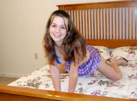 Young looking girl gets naked in high-heeled shoes on top of her bed 23349712