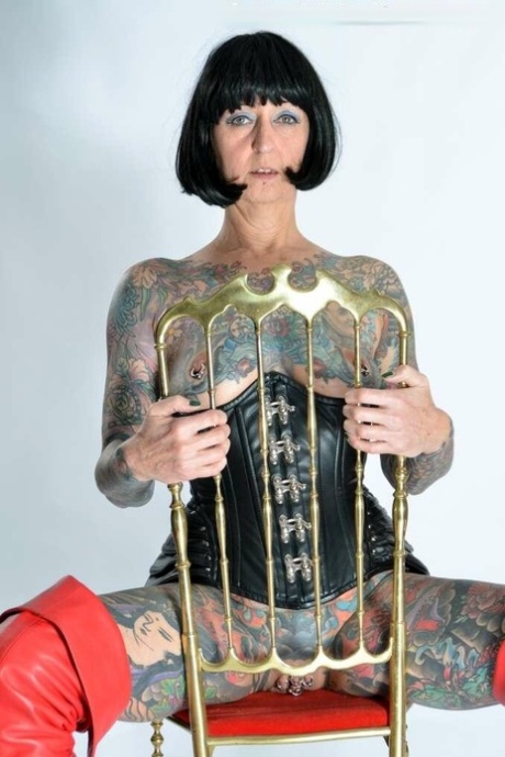 Solo girl Tattoogirl Cleo gets naked in a leather waist cincher and long boots
